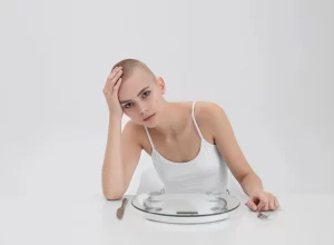 dívka, která sedí u prázdného talíře