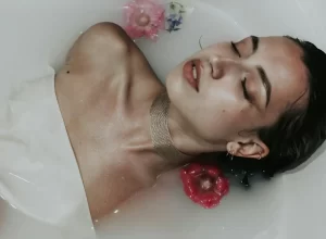 žena ve vodní lázni s květinami