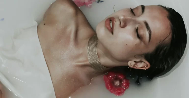 žena ve vodní lázni s květinami