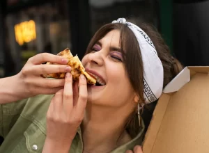 žena jí pizzu