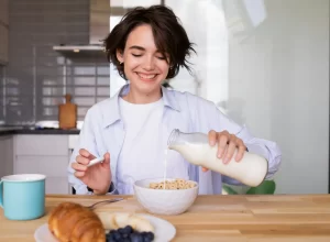 žena si lije mléko do cereálií