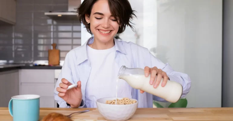 žena si lije mléko do cereálií